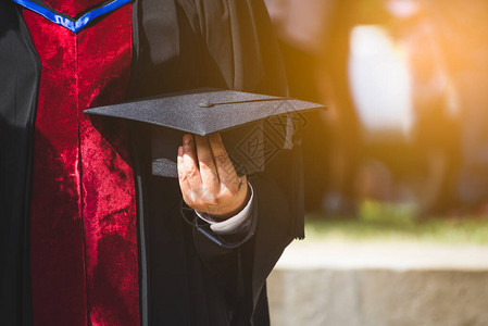 顶着帽子的近身毕业生在大学里接受成功的概念教育图片