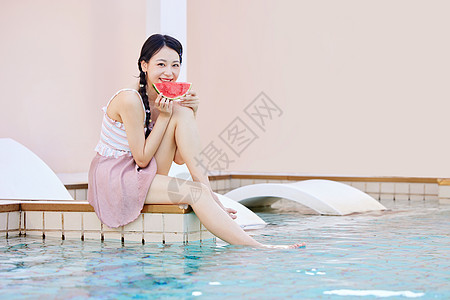 手拿西瓜在泳池边玩水的美女图片