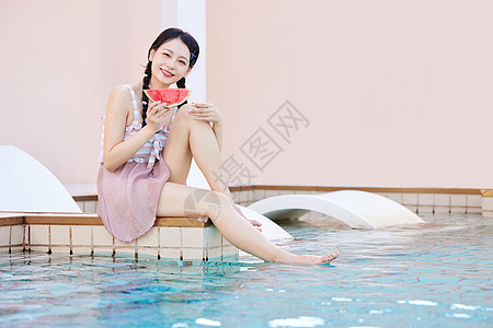 边吃边玩手拿西瓜在泳池边玩水的美女背景