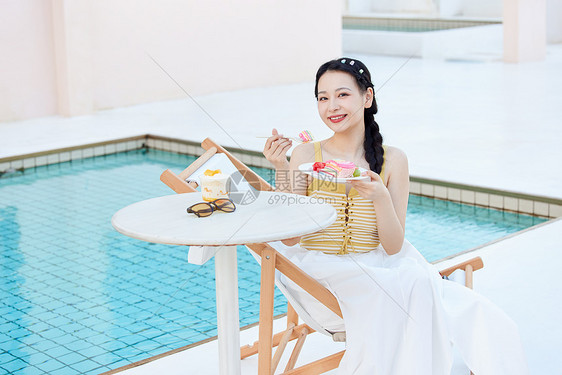 夏日美女在泳池边享受美食图片