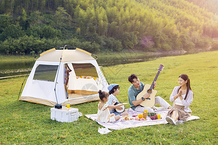 家庭欢乐野餐欢乐的家庭在户外野餐露营背景