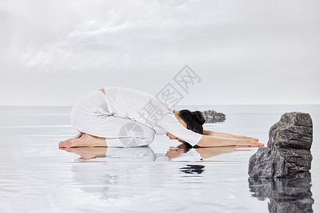 禅意水面上做瑜伽运动的女青年图片