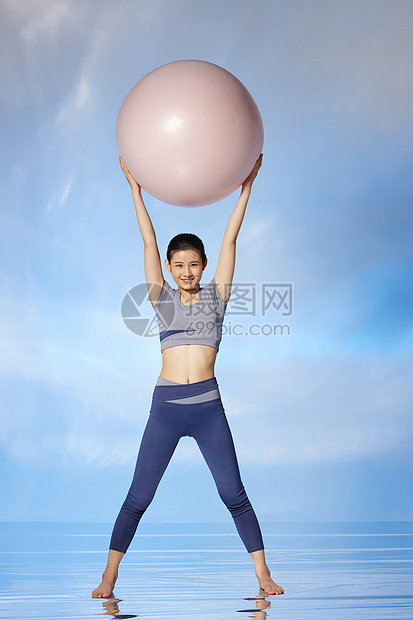 使用瑜伽球锻炼身体的女性图片