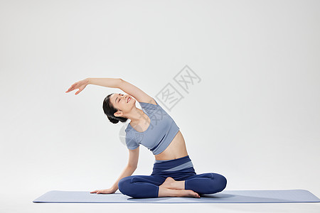 瑜伽垫上做瑜伽运动的女性图片