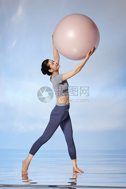 手举瑜伽球的女性运动图片