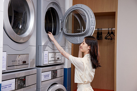 用洗衣机洗衣服的职场女性形象图片