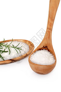 海盐在橄榄木板和碗里上面有迷迭香的草叶图片