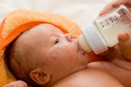 妈用奶瓶给她的男婴喝水图片