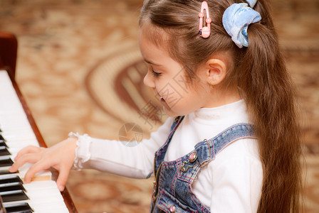小黑头发女孩在教育课上弹钢琴校对P图片