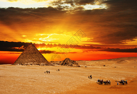 黄昏时在金字塔前穿过沙漠图片