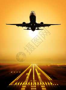 客机在日落时从机场起飞图片