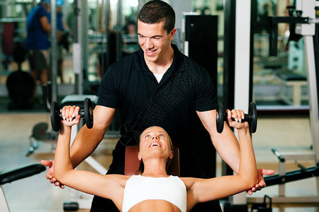 健身房的健身教练用哑铃锻炼图片