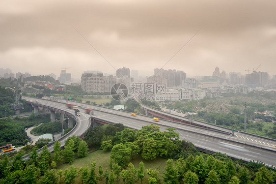 高速公路和建筑物的日落城市景观与恶劣的天气和空气污染图片