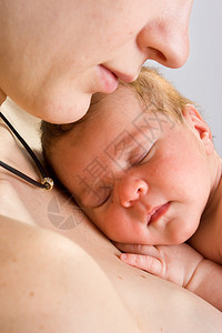 妈抱着睡的婴儿在白色的照片图片