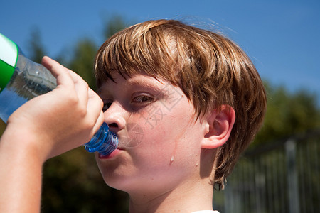 男孩在运动中流汗抽筋喝瓶背景图片