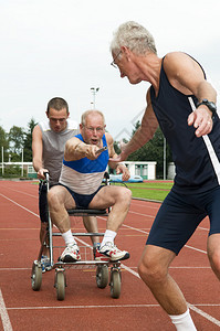残疾者及其助手帮助另一名运动员通过接力棒图片
