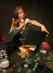 书本中的年轻女孩与电脑图片