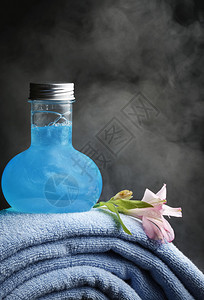 蓝色毛巾和瓶子背景是蓝色洗发水图片