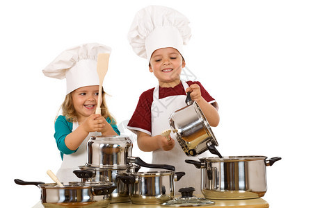 快乐的儿童厨师们用木勺敲打烹饪锅的杂图片