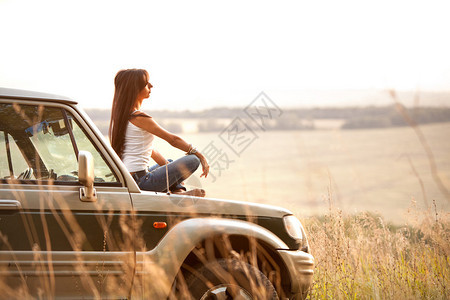 迷人的勇妇坐在车兜帽上图片