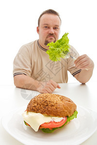 饮食选择概念男人在大型汉堡后不图片