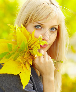 秋叶透着光秋天的女人带着黄色的秋天枫叶背景