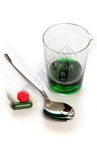 药物旧玻璃量筒中的药丸和绿色图片