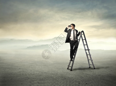 站在梯子上用双筒望远镜的商人图片