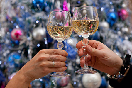双手捧着香槟酒杯靠在新年树上图片