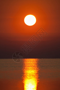 在平静的海面上的红色日落图片