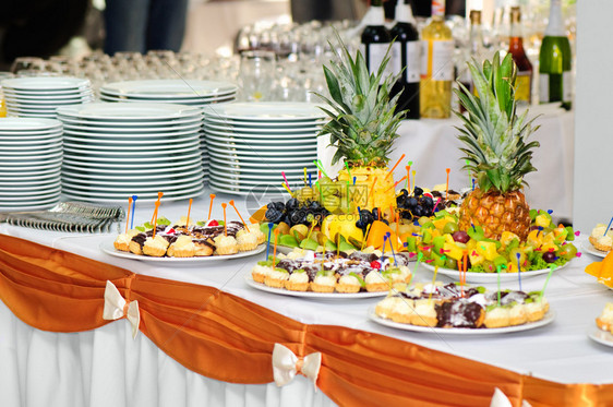 配有精美小蛋糕和水果的宴会桌图片