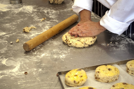 面包师双手在柜台上混合面粉以制作葡萄图片
