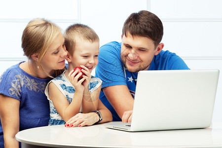三口子的幸福家庭带着电脑坐在桌子上图片