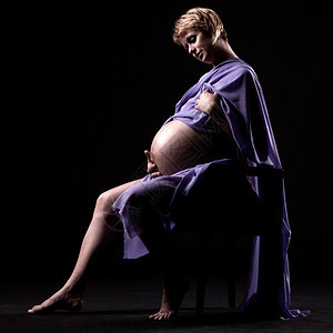9个月的孕妇坐在椅子上看着肚子图片