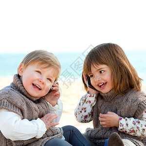 两个可爱的小女孩在沙滩上谈图片