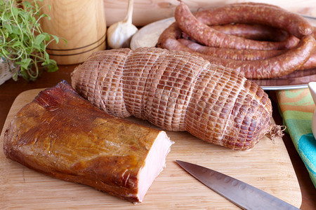 天然准备的慢速食物熏猪皮烤猪肩和火腿和环形香肠相似在木板上装图片
