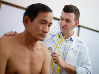 在医院用听诊器工作和看病的老年非亚洲男病人的图片