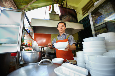 制作传统亚洲街头食品和在餐厅厨房工作的主厨图片