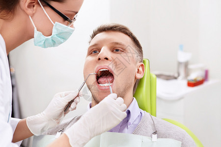 牙医在牙科诊所治疗男图片