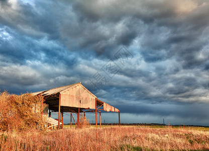 日落的乌云在暴风中散去农田上图片