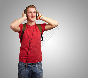 欢乐的年轻学生听音乐用耳机在玻璃上图片
