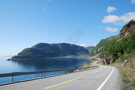 柏油路在蓝色峡湾和苔藓山之间蜿蜒曲折高速公路以递减的视角拍摄Mageroya是挪威最北部芬马克背景图片