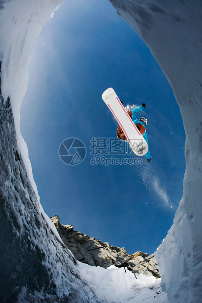 从下面看敏捷滑雪板在蓝天上跳高图片