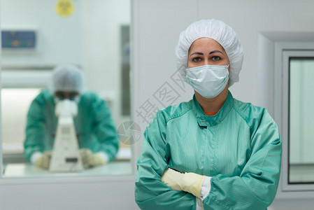 在生物技术研究中心工作的女肖像与背景中通过显微图片
