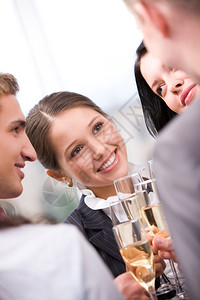 欢乐的女子在派对期间拿着长笛香槟和对同背景图片