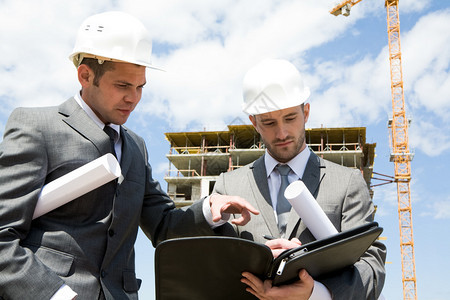 两名建筑工人站在建筑工地图片