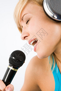 现代少女头上戴耳机将她最喜欢的歌曲唱进图片