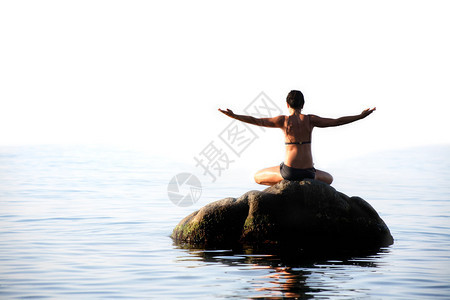 在海中石头上做瑜伽锻炼的图片
