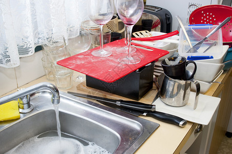 清理家里厨房水槽上的脏盘子图片