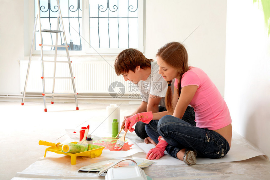 照片来自年轻夫妇在新公寓坐在地板上时混图片